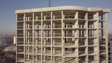 Bir şehirde inşaat halindeki yüksek apartmanın beton çerçevesinin havadan görünüşü.
