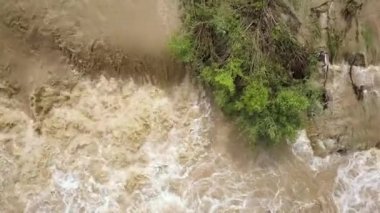 İlkbaharda sağanak yağış sırasında çamurlu suyla birlikte geniş kirli nehrin havadan görünüşü.