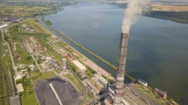 Kömür santralinden gelen gri dumanlı yüksek baca borularının havadan görüntüsü. Fosil yakıtla elektrik üretimi.