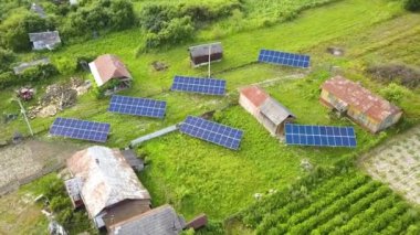 Yeşil kırsal alandaki güneş panellerinin yukarıdan aşağıya görüntüsü.