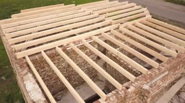 Ahşap tavan çerçeveli tuğladan bir evin havadan görünüşü.