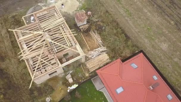 Top down aerial view of two private houses, one under construction with wooden roofing frame and another finished with red tiled roof. — Stock Footage Top Aerial View Two Private Houses One Construction Wooden Roofing Royalty Free Stock Video