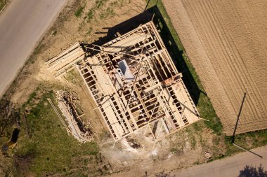 İnşaat halindeki ahşap çatı iskeleti olan bitmemiş tuğla evin havadan görüntüsü..