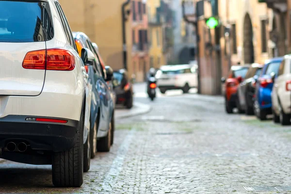 Şehir caddesinin kenarına park edilmiş modern arabalar var. Kaldırımın kenarına park edilmiş parlak araçlar. Kentsel ulaşım altyapı kavramı.