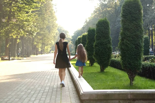 Madre Pequeña Hija Con Pelo Largo Caminando Juntas Cogidas Mano —  Fotos de Stock