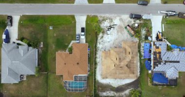 İnşaat işçileri asfalt kiremitlerle çatı inşa ediyorlar. Gayrimenkul geliştirme