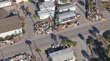 Hurda ve hurda, Florida 'daki ev alanındaki şiddetli hasar gören evlerden sonra sokak kenarındaki yığınlar halinde imha edildi. Doğal afetin sonuçları.