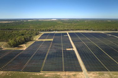 Temiz elektrik enerjisi üretmek için birçok sıra güneş fotovoltaik paneli bulunan sürdürülebilir büyük elektrik santralinin havadan görünüşü. Sıfır emisyon kavramı ile yenilenebilir elektrik.