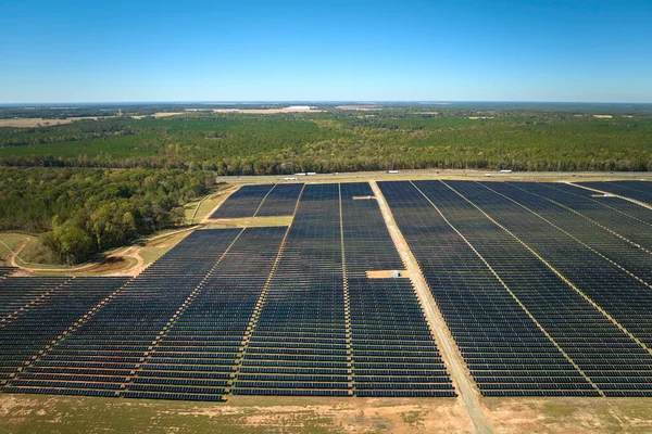 Temiz elektrik enerjisi üretmek için birçok sıra güneş fotovoltaik paneli bulunan sürdürülebilir büyük elektrik santralinin havadan görünüşü. Sıfır emisyon kavramı ile yenilenebilir elektrik.