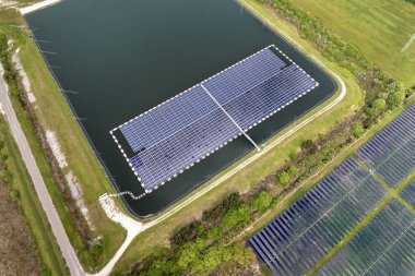 Temiz elektrik enerjisi üretmek için yüzen fotovoltaik güneş panelleri olan sanayi göleti. Su yüzeyinde hava kirliliği olmayan yenilenebilir elektrik kavramı.