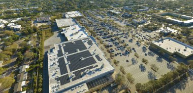 Ticari alışveriş merkezinin çatısına yeşil ekolojik elektrik üretmek için monte edilmiş mavi fotovoltaik panelleri olan güneş enerjisi santrali. Sürdürülebilir enerji konsepti üretimi.