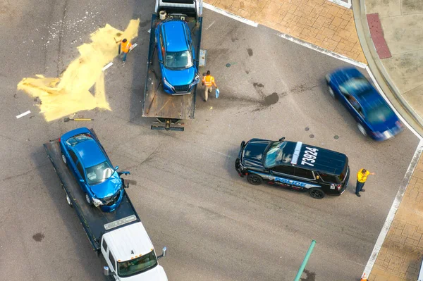 Amerikan caddesinde araba kazası. Çekici, tahrip edilmiş araba ve acil servis araçlarını alıyor. ABD 'de trafik kazası kurbanlarına yardım ediyor..