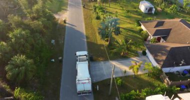 Otomatik modern çöp kamyonu Florida şehir caddesinde atık yüklüyor. Belediye hizmetleri.