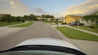 Araba bakış açısı. Florida kırsal kesimindeki evler arasında banliyö sokağında araba sürüyor. Ulaşım ve trafik kavramı