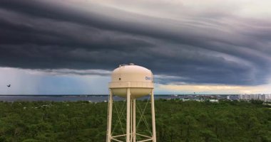 Florida yaz fırtınası Charlotte Limanı su kulesi üzerinde. Karanlık gökyüzü, şiddetli yağmur ve nemli tropikal atmosfer. Port Charlotte, Florida, ABD - 3 Ekim 2024.