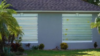 Fırtınaya dayanıklı çelik panjurlar, kasırgadan önce önlem olarak Florida 'daki evin camlarını kapatır. Ev aşırı havaya hazır..