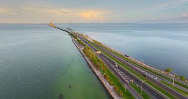Arabalar gün batımında Florida 'da Tampa Körfezi üzerinde Sunshine Skyway Köprüsü' nde yol alıyorlar. Amerika 'da ulaşım altyapısı.