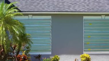 Kasırga hasarından korunmak için Florida 'daki evin camlarına çelik paneller monte edilmiş. Fırtına hazırlığı ve ev koruması.