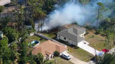 Bitki yangını ormanı yakarken itfaiyeciler ve itfaiye araçları yakındaki mahalleleri tehdit eden yangınları kontrol altına almak için çalışıyor..