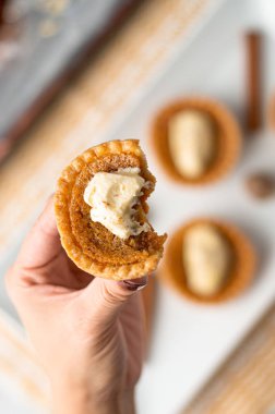 Elindeki küçük şekerli turta.