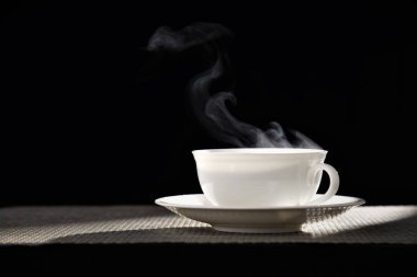 sıcak bir içecek Kupası tablo siyah arka plan üzerinde