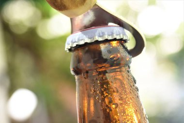 bira şişe en iyi parçası kapak açacağı yeşil bahçe bokeh arka plan ile 