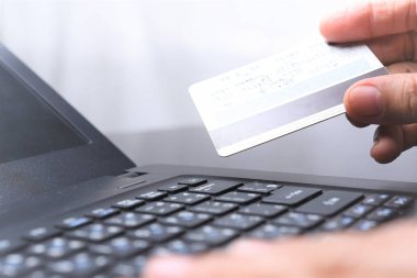 kredi kartı dizüstü bilgisayar ile online alışveriş yaparken tutan el