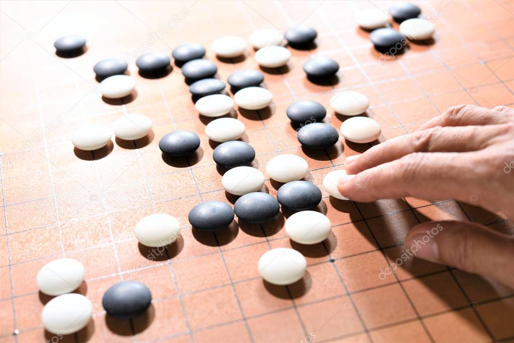 closeup hand playing go game