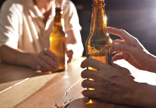 beer bottle  in man hand on wood table