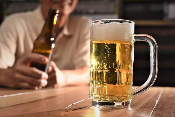 Ahşap Masada Adam Elinde Bira Şişesi — Stok fotoğraf