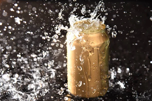 water splash drop on gold aluminium can container