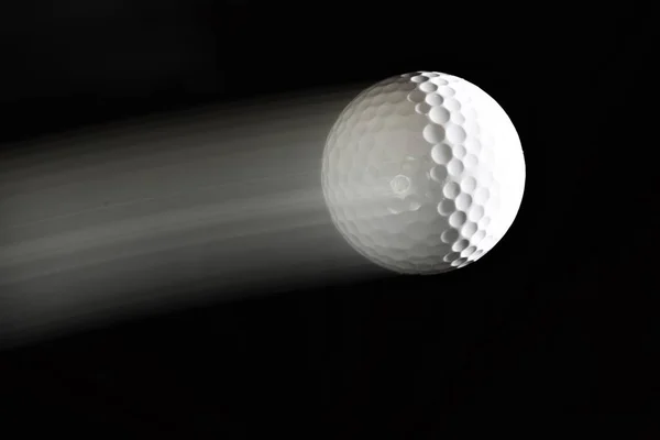 Golfball Mit Spur Dahinter Auf Schwarzem Hintergrund — Stockfoto