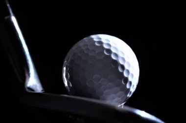 siyah arka zemin üzerinde demir kulüp başkanı ile golf topu 