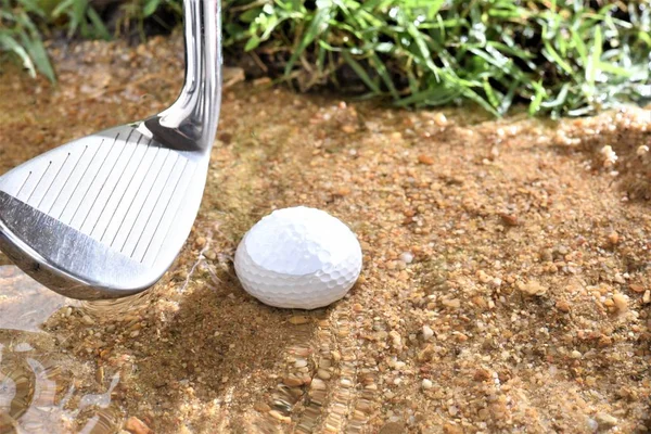 golf ball in water hazard with iron club head