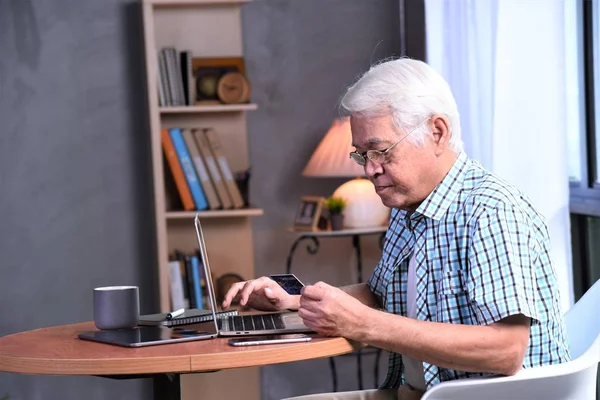 old man working with laptop computer and credit card