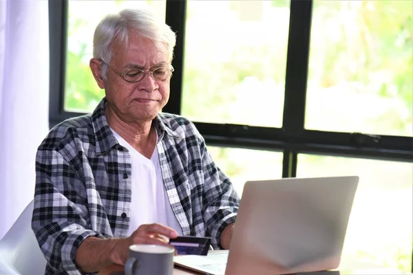 old man and laptop computer on table