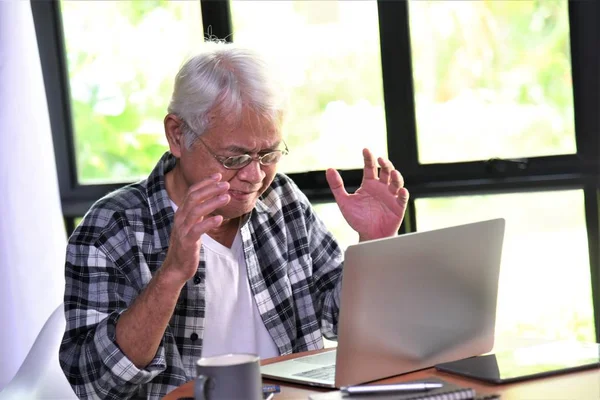 old man and laptop computer on table