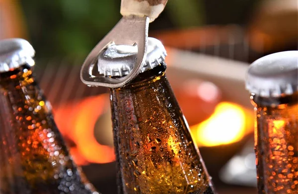 beer bottles  with opener closeup on barbecue background