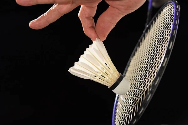 badminton racket and shuttlecock in player hand in action of serving