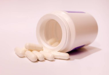 Yuvarlak kavanozun yanında beyaz haplar vardı.