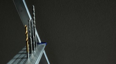 Basamakta dört matkap var.