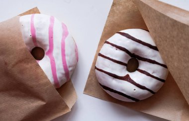 Kağıt ceplerinde pembe ve kahverengi çizgili çörekler.