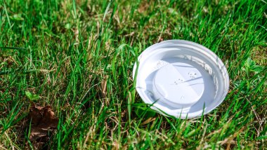 Çevre kirliliği: plastik kapak çim yatıyor.