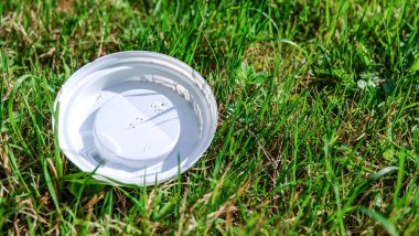 Çevre kirliliği: plastik kapak çim yatıyor.