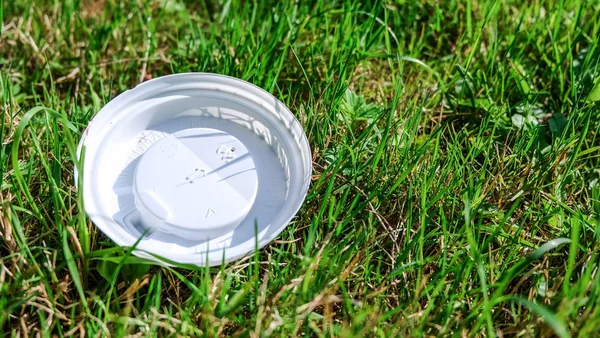 Çevre kirliliği: plastik kapak çim yatıyor.