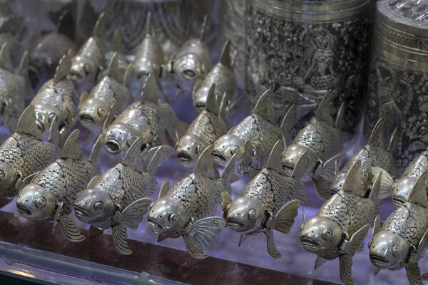 Металлические рыбы на рыбном стенде, традиционное ремесло Камбоджи. Художественный сувенирный магазин для туристов. Металлическая фигурка карпа кои. Достойный сувенир или домашний декор из Южной Азии. Металлическое литье ручной работы
