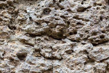Taş doku fotoğraf yıpranmış. Doğal taş arka plan. Gözenekli rock yardım. Eski taş bina yüzey closeup duvar. Taş doku sıkıntılı. Katı inşaat malzemesi. Aşınmış kaya oluşumu