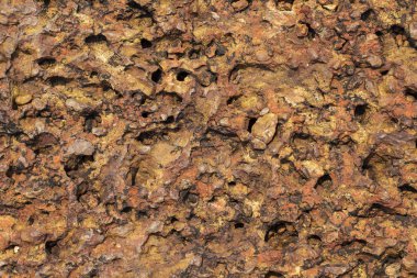 Kırmızı paslı taş doku fotoğraf. Doğal taş arka plan. Kaya kabartması yıpranmış. Eski taş bina yüzey closeup duvar. Taş doku sıkıntılı. Katı inşaat malzemesi. Aşınmış kaya oluşumu