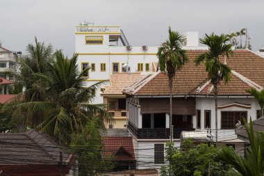 Siem Reap binalar panorama kiremit çatı üst ve palmiye ağaçları ile. Çatı görünümü Kamboçyalı şehrine. Modern cityscape Güney Asya'da. Turizm Altyapı otel ve guesthouse. Asya kentsel peyzaj