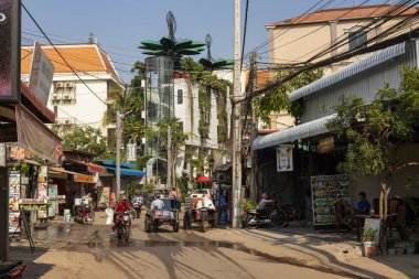 Siem Reap, Kamboçya - 25 Mart 2018: mopedler ve restoranlar ile cadde görünümü. Modern Asya şehrin sokak hayatı. Kamboçya Turizm sektöründe. Streetview taşıma ile. Motosiklet ve scooter yolda